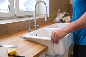 Installing Sink And Faucets During Daylight Hours. Modern Kitchen Refresh With Professional Tool Setup And Natural Light © Evgeniia Biriukova
