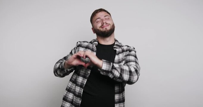 Person makes heart shape with hands and smiles in four different frames during a fun indoor activity