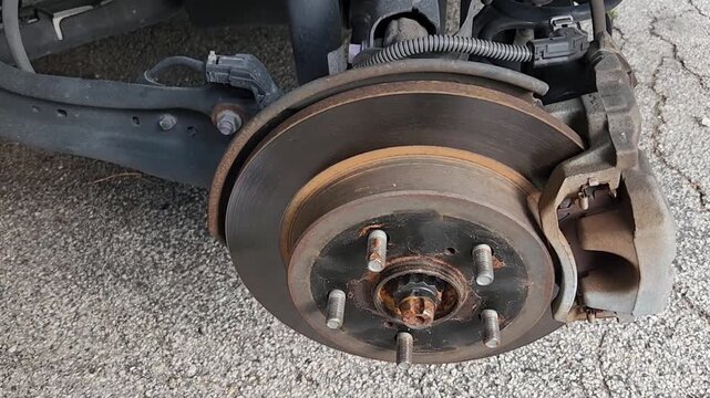 Exposed Vehicle Brake Rotor and Suspension Assembly During Wheel Removal