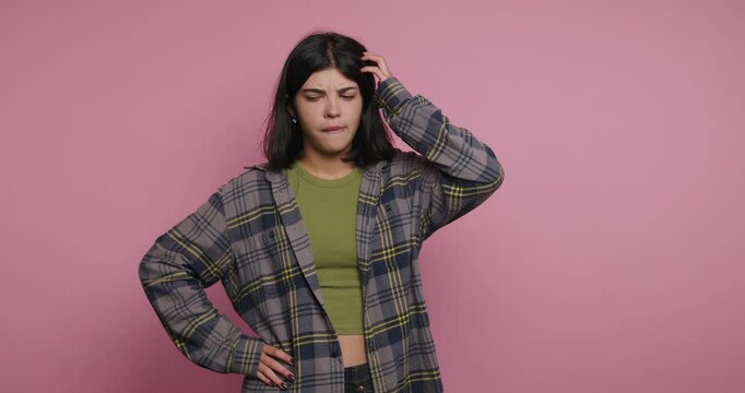Woman shows different expressions while thinking in front of a pink background during a short activity