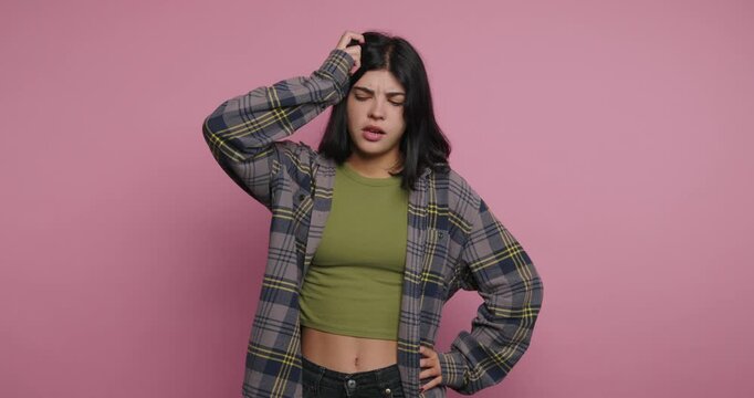 Woman shares reactions to different topics while standing against a pink background