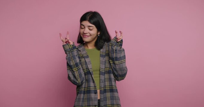 Woman makes fun gestures and expressions with simple background in studio setting