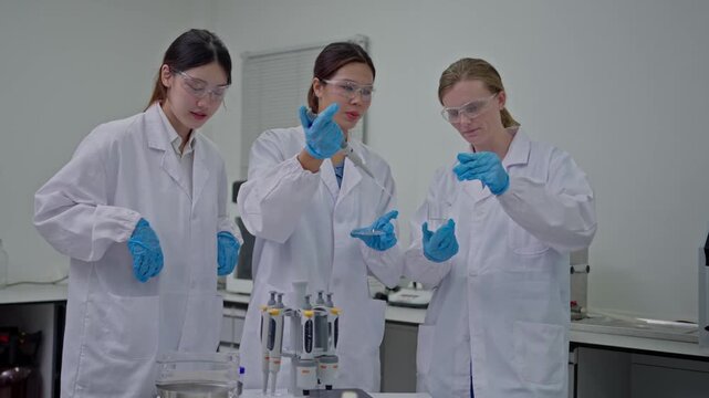 Laboratory experimentation by three female scientists in modern lab setting research activities collaborative learning environment