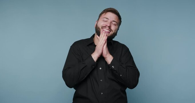 Man shows different expressions in a studio setting with a blue background during a fun activity