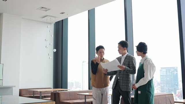 店舗施設で打ち合わせする店員・設計士・作業員