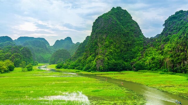 Tourists float by boat on the river of the Tam Coc National Park, Vietnam.