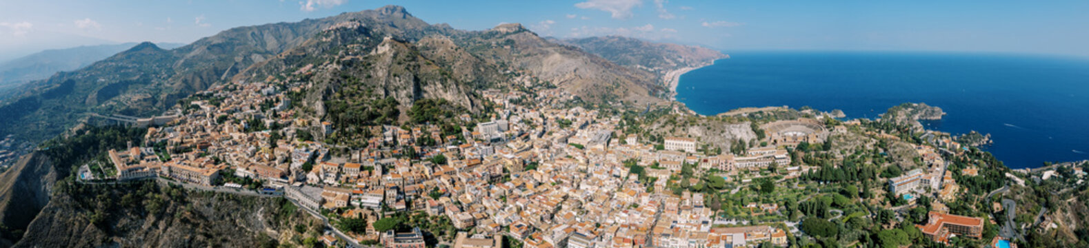 Coastal town panorama. Scenic coastal settlement with terracotta roofs and shimmering sea