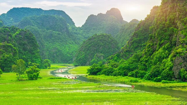 Tourists float by boat on the river of the Tam Coc National Park, Vietnam. 