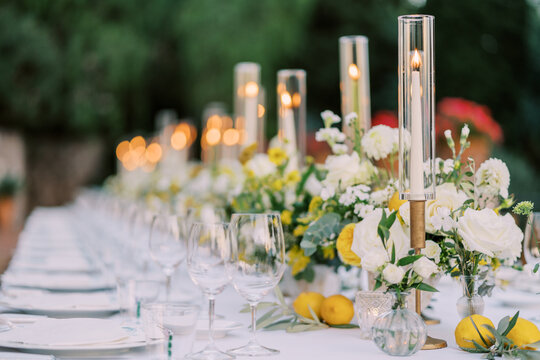 Summer feast setup. Warm candlelit dinner on decorated farmtable during sunset