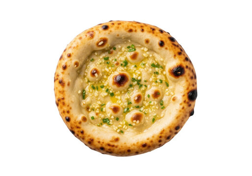 Round naan bread topped with melted garlic butter and fresh green herbs, isolated on a solid black background, top-down view of flatbread