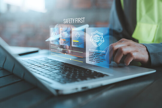 PPE compliance and zero accident concept industrial worker using laptop with holographic safety first protection level and management dashboard