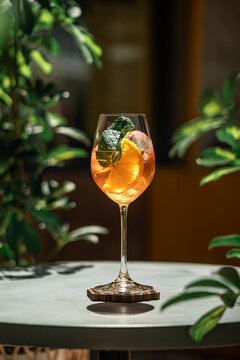 Refreshing aperol spritz cocktail served with orange slice mint and ice in wine glass