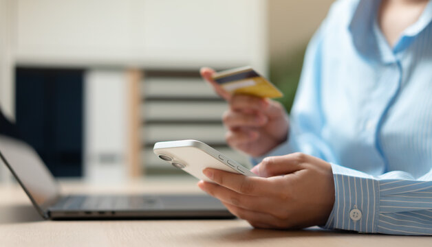 Young woman using credit card for online shopping and digital payment through mobile banking application and e-commerce platform.