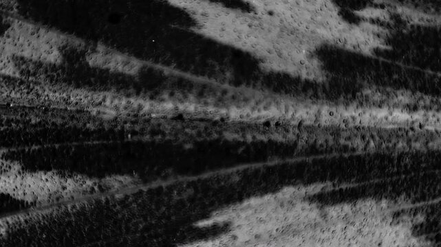 Dark abstract texture resembling damaged VHS tape noise, scratched film grain, and distorted monochrome motion patterns.