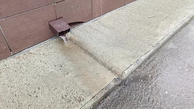 Water from the roof runs from the drainpipe to the asphalt when it rains. Rainwater drainage system