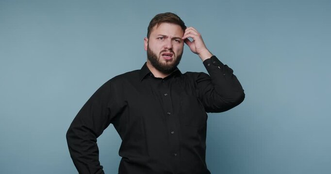 Man shows different expressions while thinking with hands on head and hip against a plain backdrop