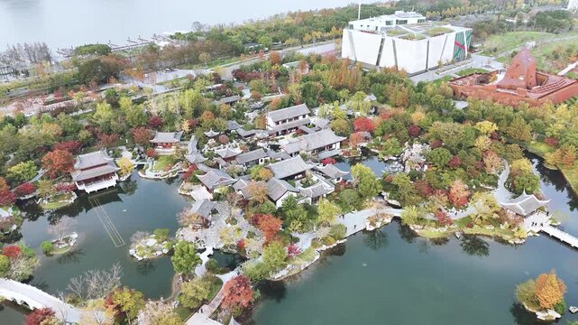 Aerial view of traditional Chinese garden with ponds and autumn trees by the lake