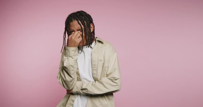 Emotions and expressions portrayed by a young man in a studio with a pink background