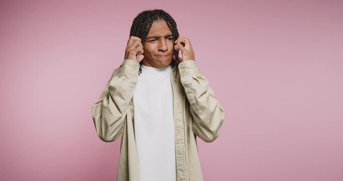 Man shows different expressions on a pink background while discussing emotions and feelings