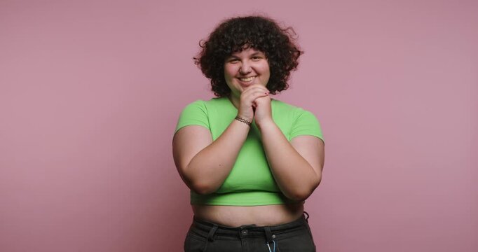 Woman shows different expressions in a photo shoot at studio with pink background in daytime