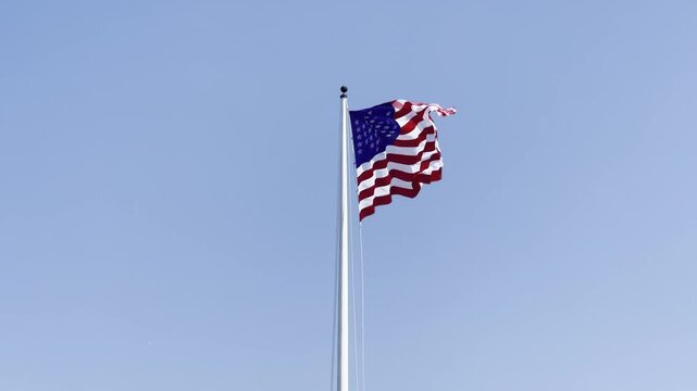 Handheld telephoto shot revealing the United States flag flying over historic Fort Sumter in Charleston, South Carolina. 4K at 30 FPS
