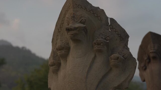 Close-up shot of a weathered naga stone carving at Prasat Hong Nang Sida near Wat Phou in Champasak, Laos.