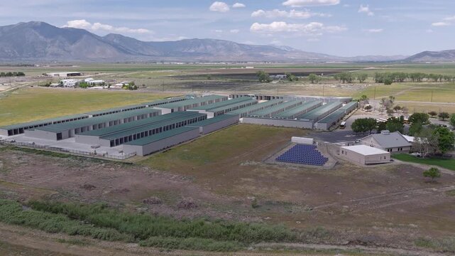 Drone zoom out shot of a self-storage unit facility with solar panels providing renewable energy, set against a vast landscape with mountains in the background in Minden, Nevada