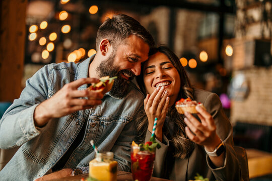Happy couple enjoying sweet food and drinks on a date