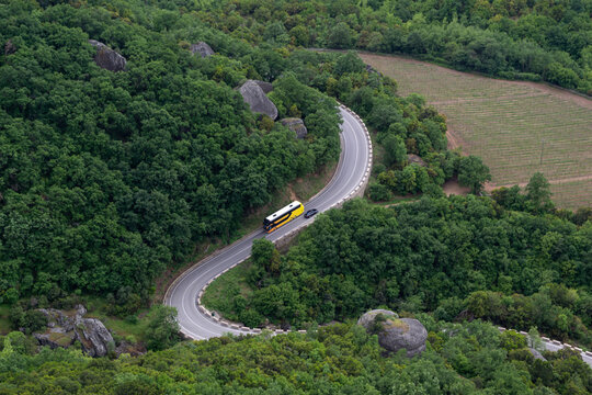 Winding road through green forest in Meteora Greece

