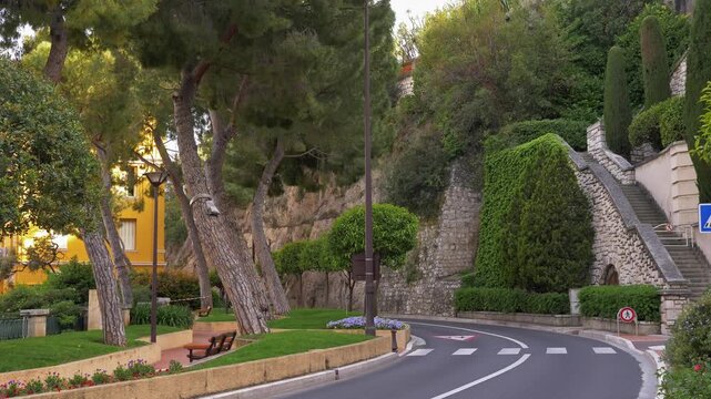 Scenic curved road bordered by manicured greenery in Monaco 4K. Monaco 7 May 2019

