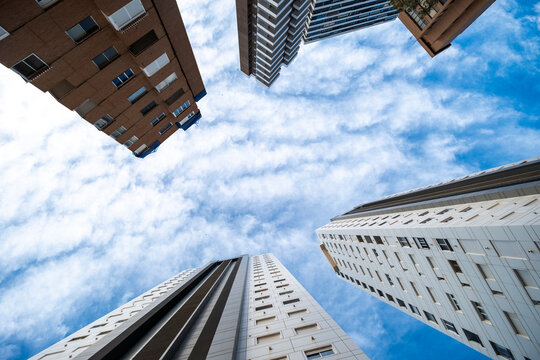 Benidorm Spain highrise towers lean above dramatic sky, creating upward urban perspective with apartment facades and coastal resort architecture