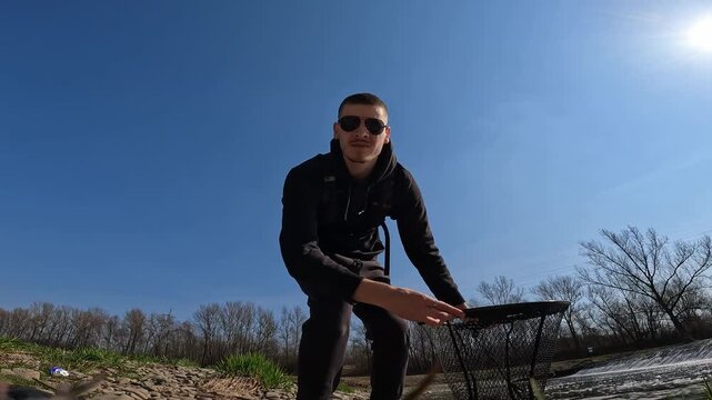 Happy Fisherman Holding a Caught European Chub (Squalius cephalus) by a River Weir. Sunny Spring Sport Fishing Lifestyle.