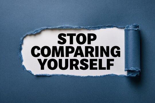 The phrase stop comparing yourself beneath ripped blue paper