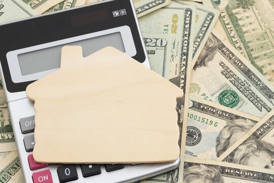 Blank wood house with calculator on twenty dollar bills for real estate and housing market