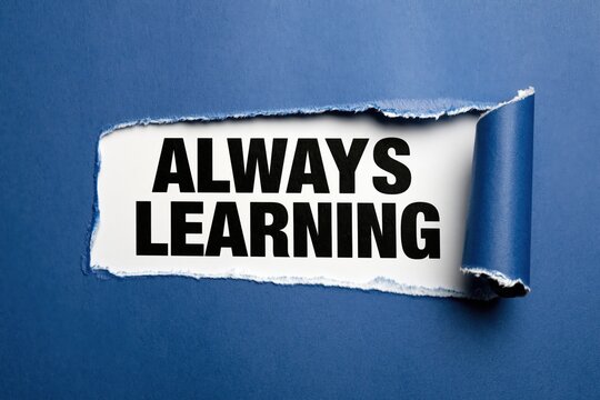 Text always learning appearing behind torn dark blue paper background