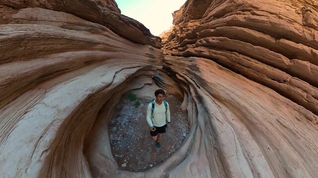 Man With 360 Degrees Camera Walking in Narrow Slot Canyon. Anniversary Narrows, Lake Mead, Nevada USA