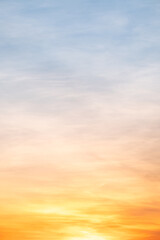 Obraz premium Sky sunset,Beautiful sunrise sky with vibrant gradient orange and gold colors and soft blue, Clear atmosphere with wispy clouds. Peaceful, perfect for background and copy space, vertical