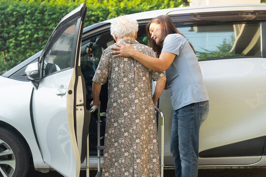 Caregiver help Asian elderly woman disability patient get into car.