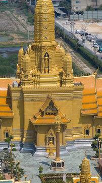 Aerial view of the golden stupa and intricate architecture of a traditional Thai temple with orange tiled roofs and statues in a courtyard Bangkok, Bangkok, Thailand.