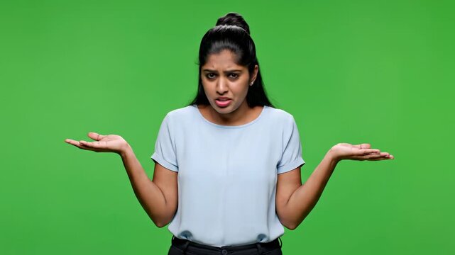 Confused young woman shrugging shoulders with uncertain expression on green screen