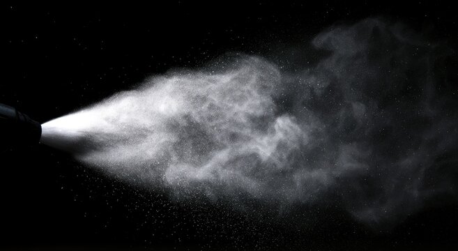 White mist blasts from a dark nozzle against a black background