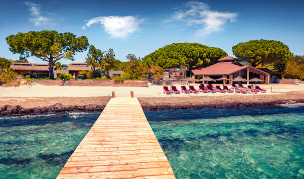 Warm summer scene of Santa Giulia beach with wooden pier. Bright morning view of resort on Corsica island, France, Europe. Splendid Mediterranean seascape. Vacation concept background.