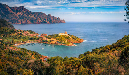Naklejka premium Splendid morning view of Port de Girolata with old fortress on the edge on cape. Amazing summer scene of Corsica island, France, Europe. Sunny Mediterranean seascape. Traveling concept background.