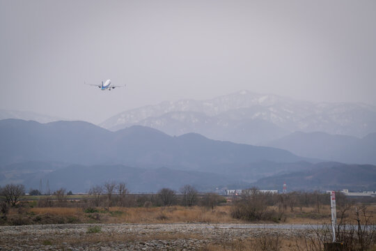 Airplane landing and take off at the airport in the city where we can see Japan alps background Toyama Japan 
