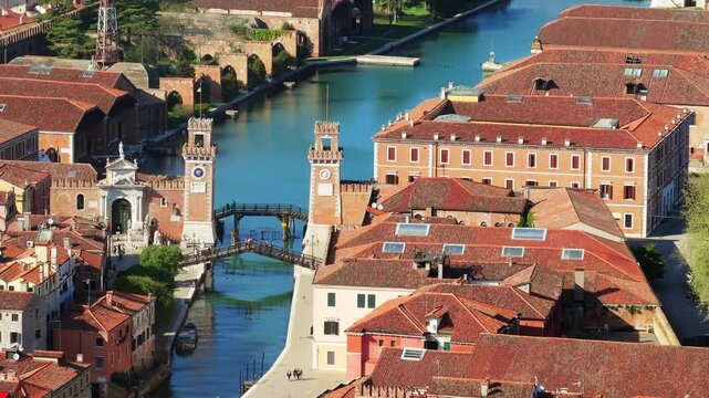 Aerial view of historical venetian architecture featuring water canals and iconic towers at the venice arsenal entrance.