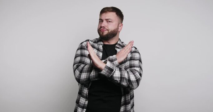 Man making hand gestures for communication in studio setting showing no and stop signals