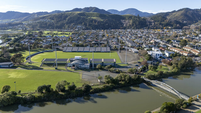 Aerial view of Trafalgar Park stadium with its green pitch and grandstands next to the Maitai River and a pedestrian bridge in Nelson, Nelson Region, New Zealand.