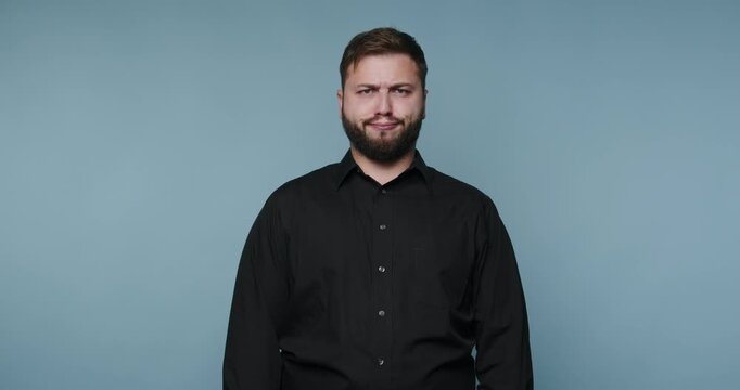 Man shows four different expressions against a plain blue background during a short session in a studio
