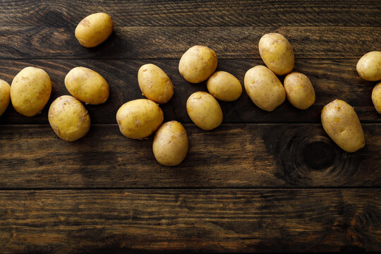 Fresh raw whole potatoes on rustic wooden table, top view
