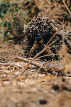 military camouflage equipment. A soldier with a machine gun dressed in a kikimora on a position